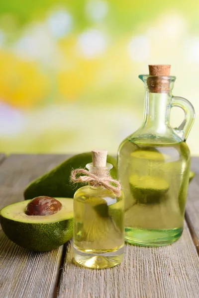 Avocado oil on table on light background — Stock Photo, Image