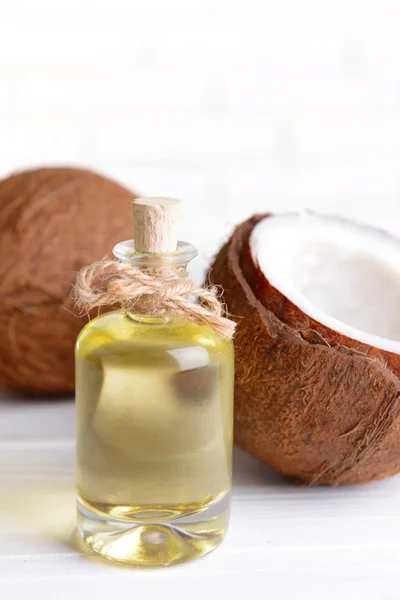 Olej kokosowy na stole na jasnym tle — Zdjęcie stockowe