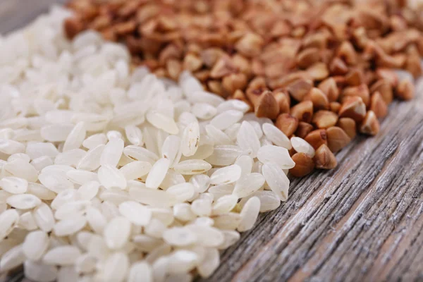 Reis und Buchweizen auf Holzgrund — Stockfoto