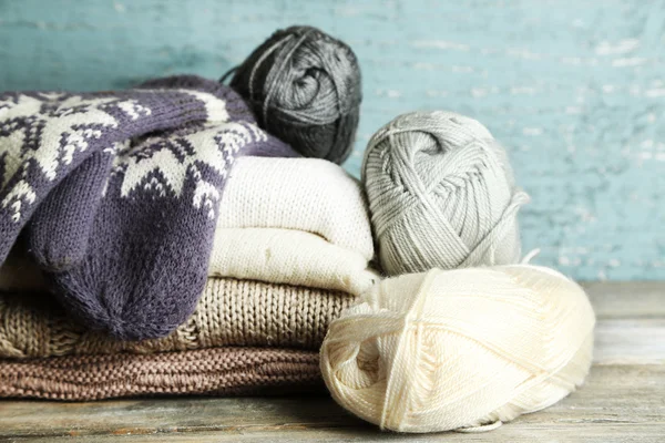 Πλέξιμο ρούχα, νήματα και γάντια, σε ξύλινο φόντο — Φωτογραφία Αρχείου
