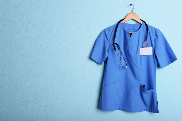 Arts shirt met stethoscoop op hanger op blauwe achtergrond — Stockfoto