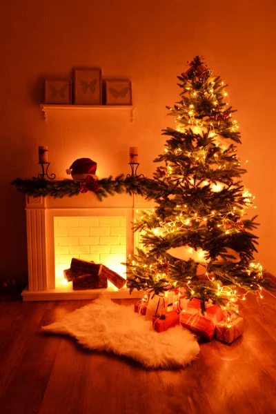 Árbol de Navidad cerca de chimenea en la habitación —  Fotos de Stock