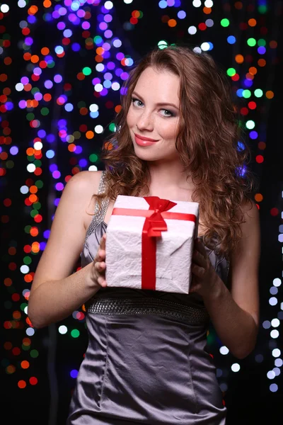 Portrait of beautiful young girl on bright lights background — Stock Photo, Image
