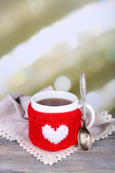 杯可口的热奶茶，木制的桌子，在明亮的背景上 — 图库照片