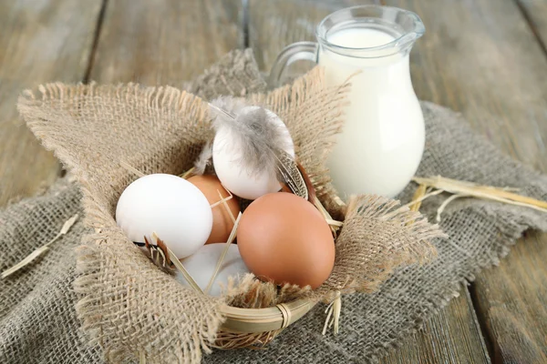 Ägg och färsk mjölk i Glaskanna, på trä bakgrund. Ekologiska produkter koncept — Stockfoto