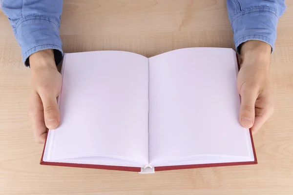 Män läser tömma öppen bok på träbord bakgrund — Stockfoto
