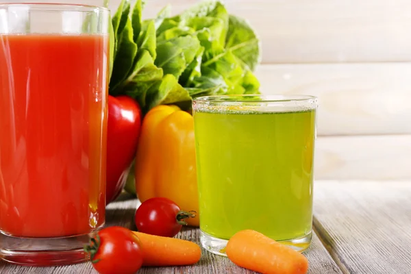 Jugo de verduras y verduras frescas en mesa de madera sobre fondo de pared de madera — Foto de Stock