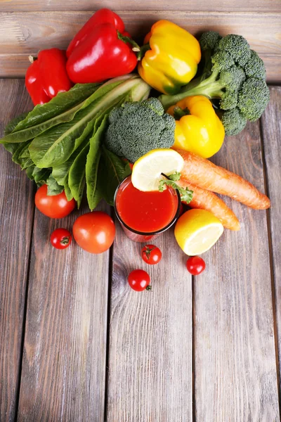 Tomatensaft im Glas und frisches Gemüse auf Holzgrund — Stockfoto