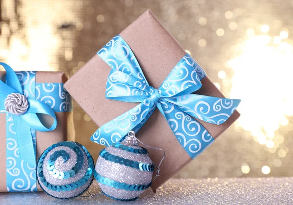 Cajas de regalo con cinta azul y juguete árbol de Navidad en la mesa sobre fondo brillante —  Fotos de Stock