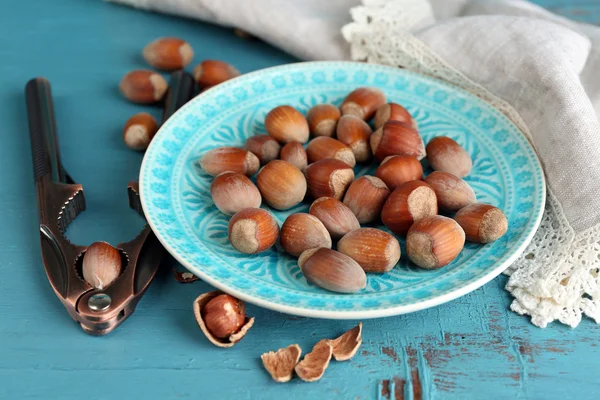 Hazelnuts on blue plate — Stock Photo, Image