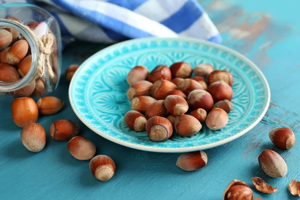 Hazelnuts on blue plate — Stock Photo, Image