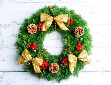 Ahşap arka plan üzerinde ökseotu ile dekoratif çelenk yapraklar Noel