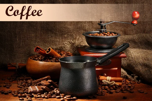 Coffee grinder, turk and cup of coffee on burlap background — Stock Photo, Image
