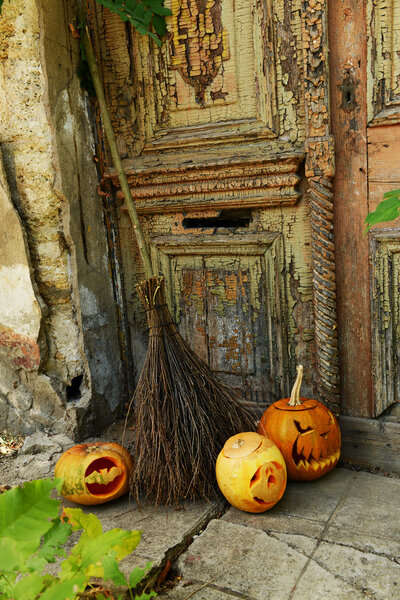 Тыква и метла для отдыха Хэллоуин на старом деревянном фоне двери
