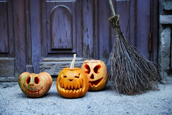 Sütőtök és nyaralás a régi fából készült ajtó háttér Halloween seprű — Stock Fotó