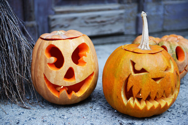 Тыква и метла для отдыха Хэллоуин на старом деревянном фоне двери
