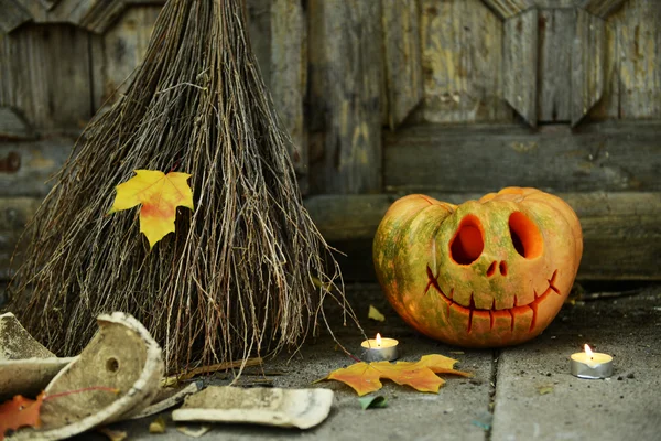 Calabaza y escoba para Halloween en el fondo de la puerta de madera vieja —  Fotos de Stock