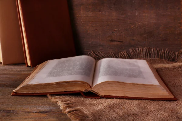 Livros sobre guardanapo na mesa de madeira no fundo da parede de madeira — Fotografia de Stock