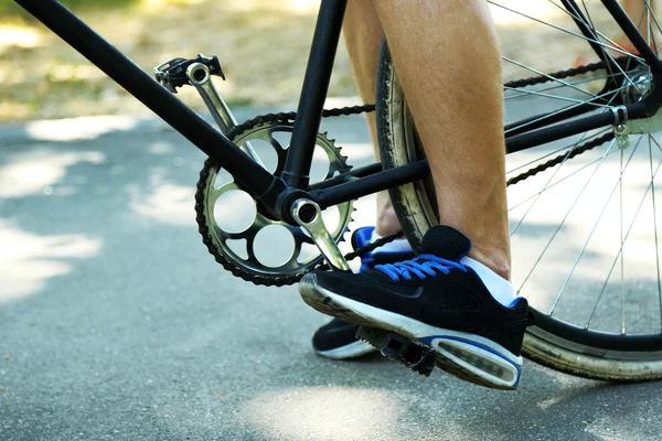 Young man riding bike in city park — Stock Photo, Image