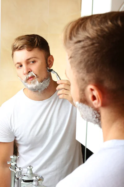 Młody człowiek golił brodę w łazience — Zdjęcie stockowe