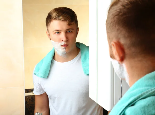 Jovem barbear sua barba no banheiro — Fotografia de Stock