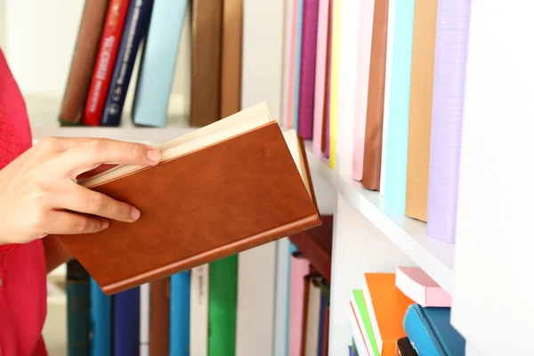 Livro de escolha de mão na biblioteca — Fotografia de Stock