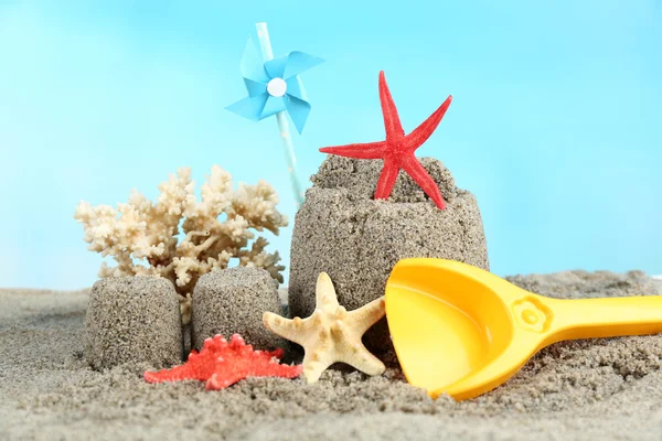 Sandcastle with pinwheel on sandy beach — Stock Photo, Image