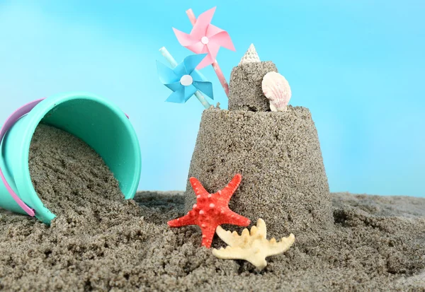 Sandcastle with pinwheel on sandy beach — Stock Photo, Image