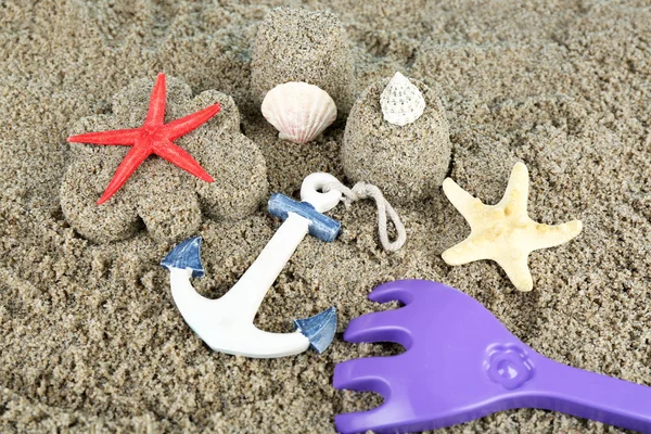 Sabbia a forma di fiore e castello, stelle marine e giocattoli per bambini primo piano — Foto Stock