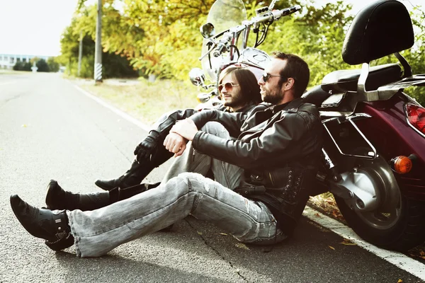 Motorkář muži sedí u kol a relaxaci — Stock fotografie
