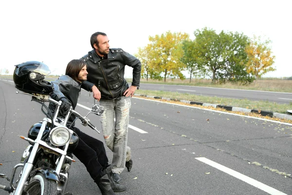 Dois motociclistas perto de motocicleta na estrada — Fotografia de Stock