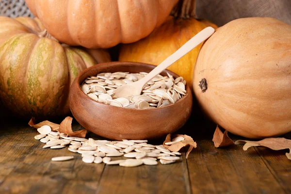 Pumpkins and seeds in bowl — Stock Photo, Image