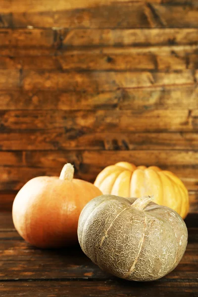 Ripe different pumpkins on wooden background — Stock Photo, Image