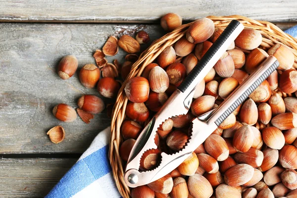 Hazelnuts on wicker mat on wooden background — Stock Photo, Image