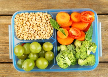 ahşap masa üzerinde plastik kutu lezzetli Vejetaryen yiyecekler