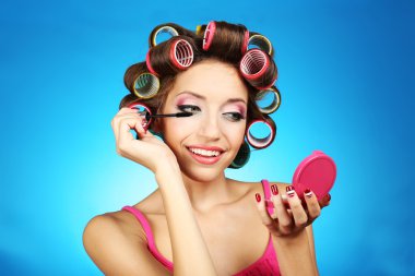 mavi zemin üzerine saç curlers içinde güzel bir kız