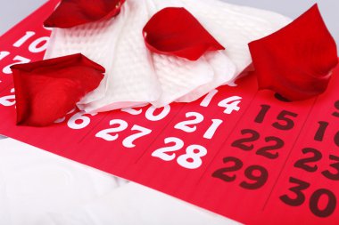 Hijyenik pedler ve gül yaprakları üzerinde Takvim arka plan üzerinde ahşap masa