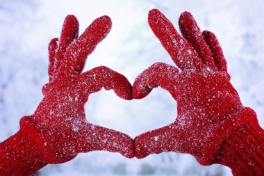 Kadının kış doğal zemin üzerine kırmızı eldiven eller