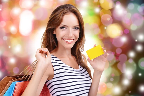 Conceito de compras. Mulher bonita com sacos de compras no fundo da loja — Fotografia de Stock