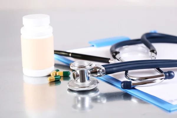 Stethoscoop, pillen en flessen op lichte achtergrond. geneeskunde concept — Stockfoto