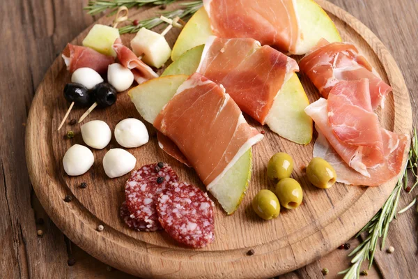 Delicious melon with prosciutto on table close-up — Stock Photo, Image