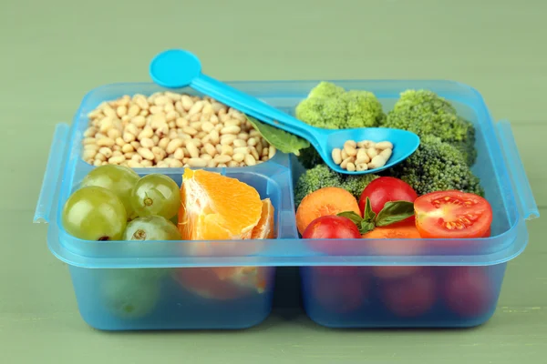 Smakelijke vegetarische maaltijden in plastic doos op groene houten tafel — Stockfoto