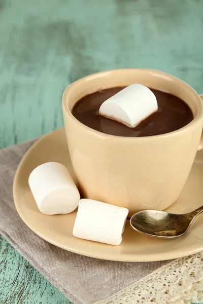 Chocolate quente com marshmallows na caneca, no fundo de madeira — Fotografia de Stock