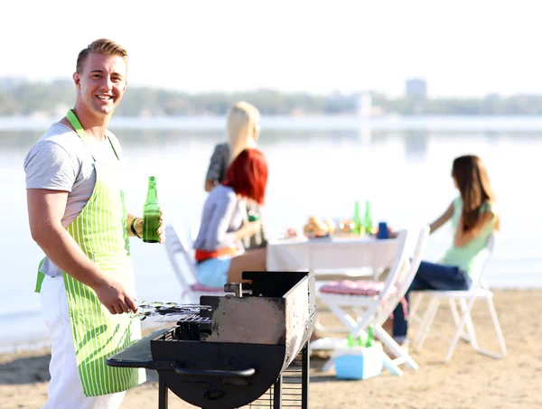 Unge venner som har grillfest, ute – stockfoto