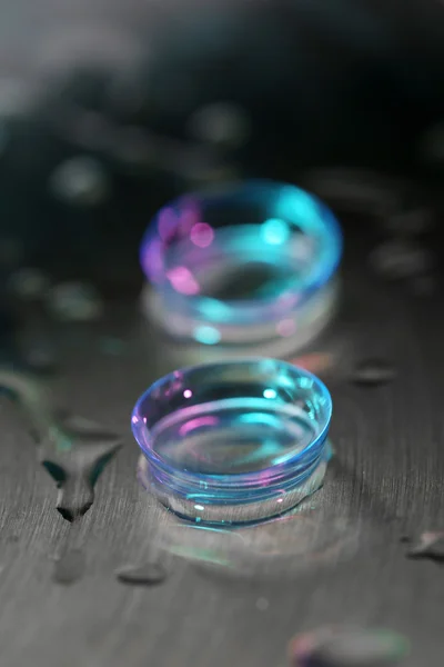 Lentilles de contact avec gouttes d'eau sur fond lumineux — Photo