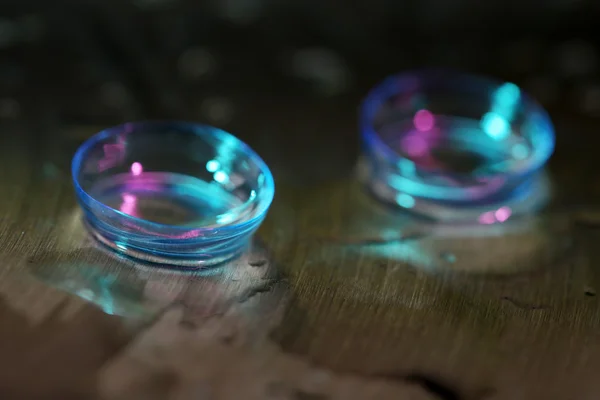 Lentes de contacto con gotas de agua sobre fondo brillante — Foto de Stock