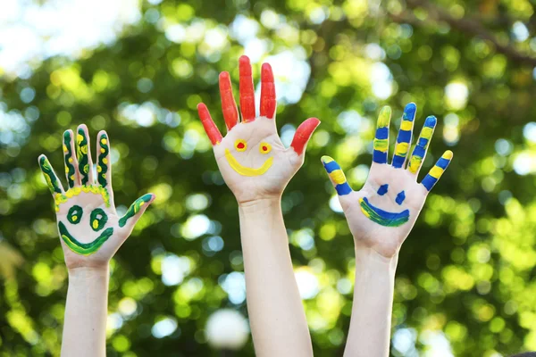 Renkli gülümseyen doğal zemin üzerine eller