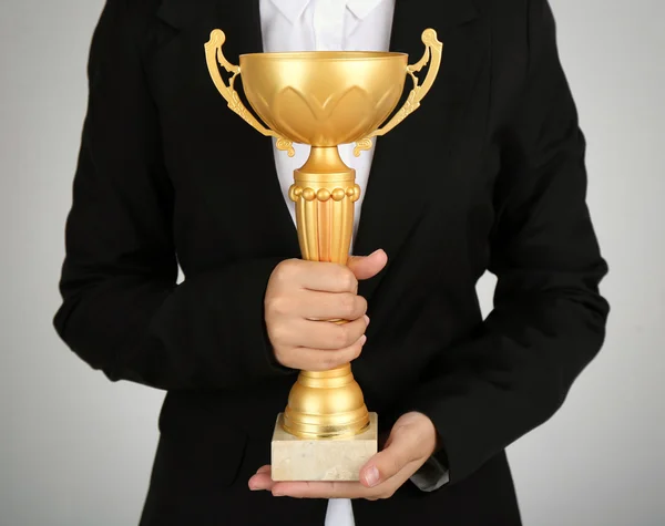 Mulher segurando copo de troféu no fundo de cor — Fotografia de Stock