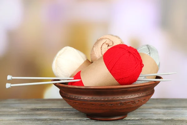 Breien garen met breinaalden op houten tafel, op lichte achtergrond — Stockfoto