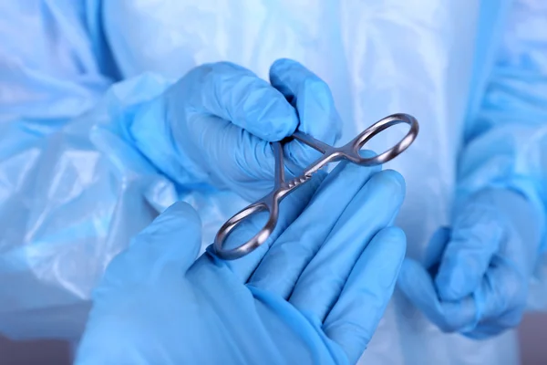 Mãos de cirurgião segurando instrumento médico close-up — Fotografia de Stock